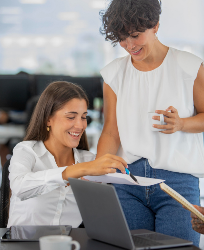 Compañeras de trabajo revisando la nómina brindando el servicio de bpo nómina